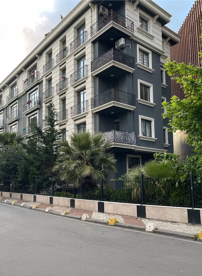 Ferforje balkonlu, gri ve krem tonlarında konut cephesi