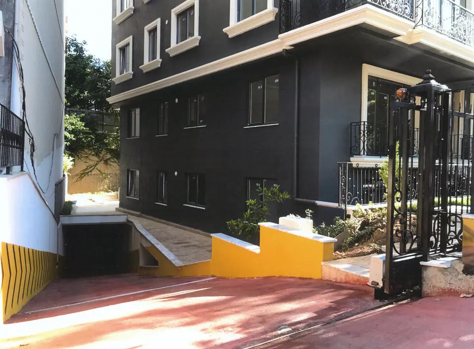Sarı çizgili otopark rampası ve bina girişi
